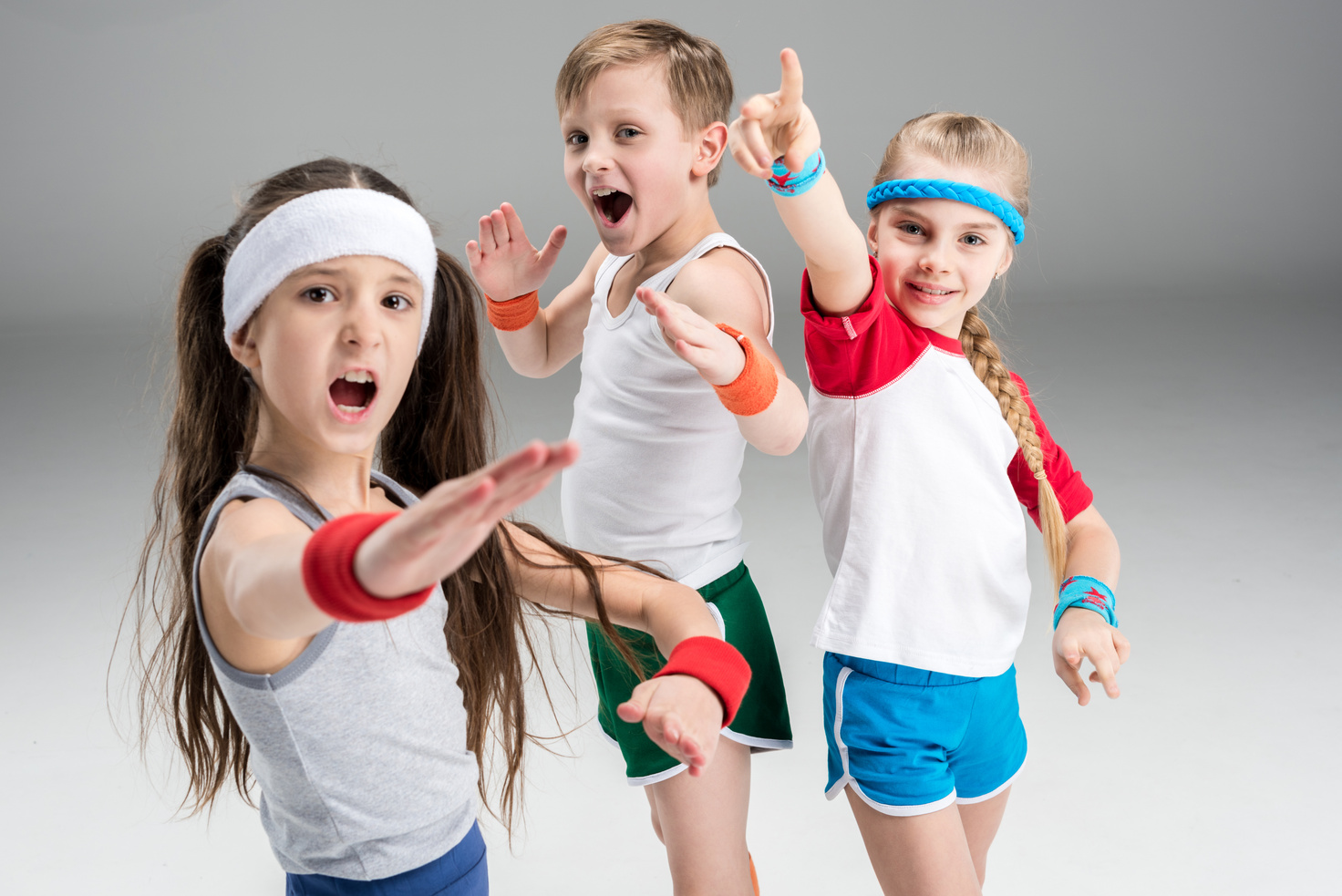 Group of sporty children in sportswear exercising together isolated on grey, children sport concept